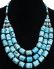 Collier ethnique pieces turquoises imitation corail agremente de perles et de metal argente cisele